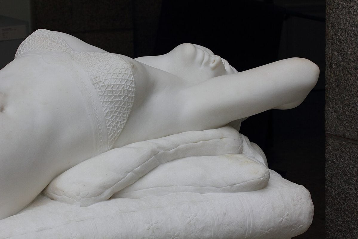 Marble sculpture of Roman Empress Messalina reclining, created by French artist Eugène Cyrille Brunet in 1884.