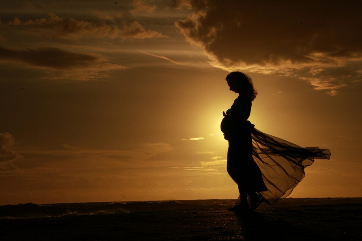 silhouette of pregnant woman at sunset